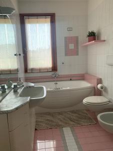 y baño con bañera, aseo y lavamanos. en Appartamento Gli Ulivi, 