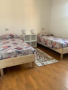1 dormitorio con 2 camas y alfombra en Appartamento Gli Ulivi, 