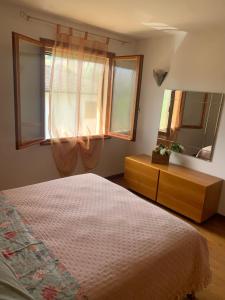 1 dormitorio con cama, tocador y espejo en Appartamento Gli Ulivi, 