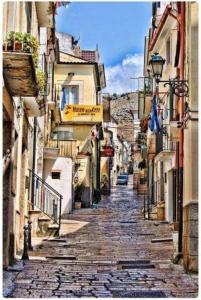 una calle estrecha con edificios a ambos lados. en Art House Centro - Gargano, en San Giovanni Rotondo