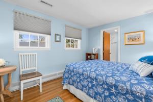 een slaapkamer met blauwe muren en een bed en een bureau bij 84 Cranberry Lane Chatham Cape Cod ~ Ridgevale Retreat in South Chatham