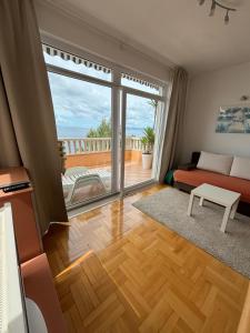 ein Wohnzimmer mit einem Bett und einem großen Fenster in der Unterkunft Villa Spomenka in Podgora