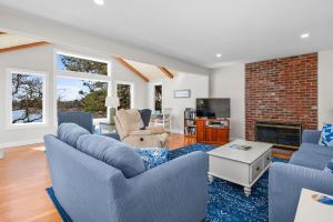 een woonkamer met blauwe stoelen en een stenen open haard bij 84 Cranberry Lane Chatham Cape Cod ~ Ridgevale Retreat in South Chatham