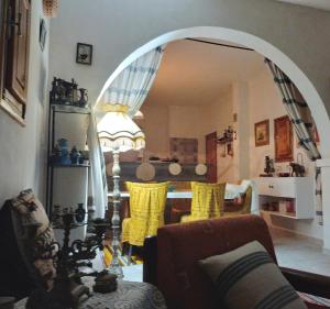 einen Torbogen im Wohnzimmer mit einem Tisch und Stühlen in der Unterkunft Djerba Rêve Vacances Emna EL Beya in Midoun