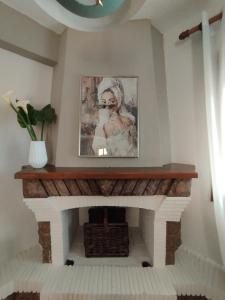 a fireplace in a living room with a picture on the wall at OLYMPUS HILL in Litochoro