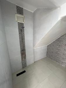 a white room with a shower with a tile wall at le calme in Essaouira