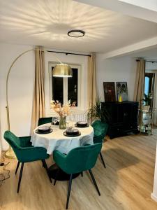 ein Esszimmer mit einem Tisch und grünen Stühlen in der Unterkunft Casita am Baldinger Tor in Nördlingen