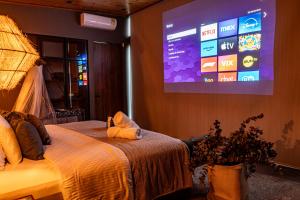 um quarto com uma cama e um grande ecrã em La Casita Filandia em Filandia