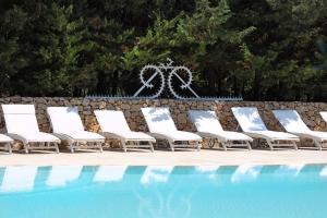 a group of lounge chairs next to a swimming pool at Maison D'Enrì in Gallipoli