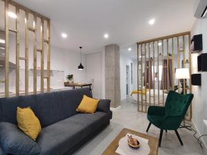 a living room with a blue couch and a green chair at Ferola Homes in Granada