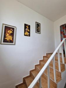 a staircase with three pictures on the wall at Къща за гости Пантови in Gramatikovo