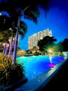 a large swimming pool with palm trees and a building at Haus of Emerald Studio Condo - Saekyung 956 Looc in Cebu City +9 photos