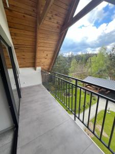 a balcony in a house with a view of the woods at Domki i Apartamenty Wypoczynkowe Lidzbark in Lidzbark