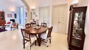 a dining room with a wooden table and chairs at Tramonto in Santa Maria al Bagno