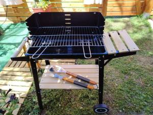 a grill in the yard with a bench next to it at lou caladou gîte en pierre avec bain à remous in Vallon-Pont-dʼArc +32 photos