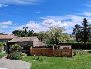 a house with a wooden fence in a yard at lou caladou gîte en pierre avec bain à remous in Vallon-Pont-dʼArc
