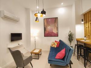 a living room with a blue couch and a table at Ferola Homes in Granada