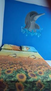 Apartamento Amoblado cerca al mar في كارتاهينا دي اندياس: لوحة لطائر على سرير مع ورود