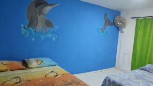 een slaapkamer met een dolfijnmuurschildering aan de muur bij Apartamento Amoblado cerca al mar in Cartagena