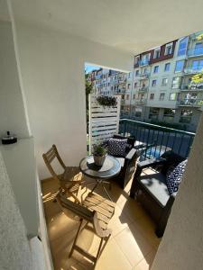 a balcony with a table and chairs and a building at Apartament Promyk in Świnoujście