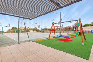un parque infantil con columpio en una pista de tenis en Villa Infinity sea views I Pool I BBQ I Jacuzzi, en Almería
