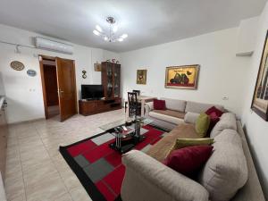 a living room with a couch and a table at Lovely spacious house with big garden in Elbasan