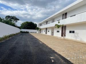 an empty road in front of a white building at Departamento Bohen 13 in Mérida