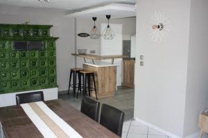a dining room with a table and a green wall at Bretzel et Cigogne in Ostheim