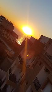 an image of the sun setting over buildings at Appartement bord de mer in Mazer +4 photos