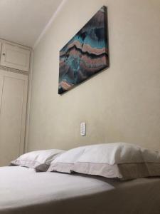 um quarto com uma cama com um quadro na parede em Energia Perfeita Casa Solar Milagres em Americana