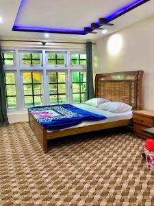 ein Schlafzimmer mit einem großen Bett mit blauer Decke in der Unterkunft Al Jannat Hotel & Relax Inn Guest House Skardu in Skardu