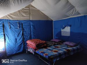 a room with a bed in a blue and white tent at Gurgaon Paradise Resort Tapovan, Rishikesh in Rishīkesh