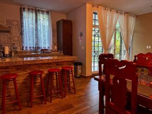 una cocina con barra con taburetes rojos en Cabaña/casa Wolf, 