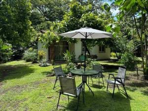 a table and chairs with an umbrella in a yard at Cabaña/casa Wolf 