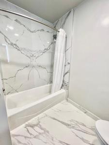 a bathroom with a marble shower curtain and a tub at Nob Hill Motor Inn -Newly Updated Rooms! in San Francisco