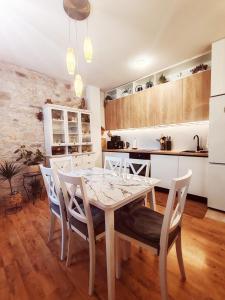 a kitchen and dining room with a table and chairs at Apartman Hygge in Omiš +4 photos