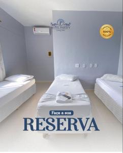 um quarto com duas camas com um sinal para um spa em Hotel Paraty em Camaçari