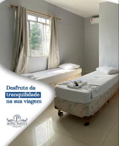 um quarto com duas camas e uma janela em Hotel Paraty em Camaçari