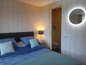 1 dormitorio con cama azul y espejo en Bed & Breakfast in ons Bakhuis, en Apeldoorn
