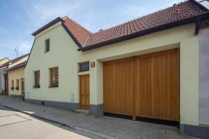 Casa blanca con puertas de madera en garaje en una calle en Apartmány Pod náměstím 2 en Telč