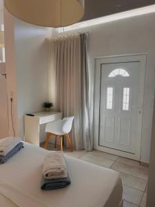 - une chambre avec un lit, une chaise et une porte dans l'établissement CreteSuites - Urban Villa with Pool - 500m to the Beach, à Réthymnon