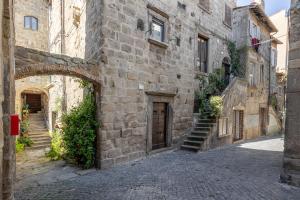 un callejón en un antiguo edificio de piedra con una puerta en L'Alloggio di San Pellegrino, en Viterbo