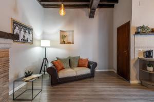 una sala de estar con un sofá y una mesa en L'Alloggio di San Pellegrino, en Viterbo