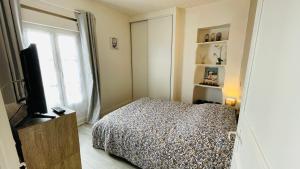 a bedroom with a bed and a flat screen tv at AppartementT2 à 200m des Thermes in Saujon