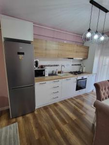 a kitchen with white cabinets and a stainless steel refrigerator at Pink Galaxy in Baciu