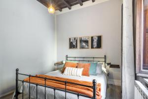 Un dormitorio con una cama con almohadas naranjas. en L'Alloggio di San Pellegrino, en Viterbo 17 fotos más