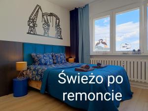 シュチェチンにあるGood Night in Szczecinのベッドルーム(青いベッド1台、窓付)