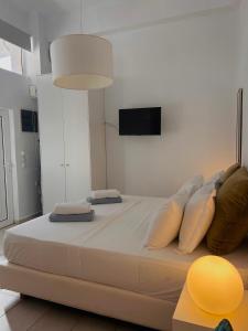 Elle comprend un grand lit blanc avec des oreillers. dans l'établissement CreteSuites - Urban Villa with Pool - 500m to the Beach, à Réthymnon