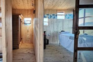 Pokój z łóżkiem i drewnianą podłogą w obiekcie ECOREFUGIO w mieście Colbún