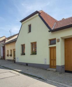 テルチにあるApartmány Pod náměstím 2の茶色の扉のある白い家